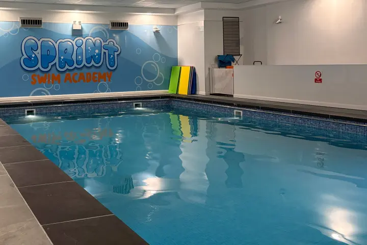 Adults using swim noodles in the pool at Sprint Swim Academy